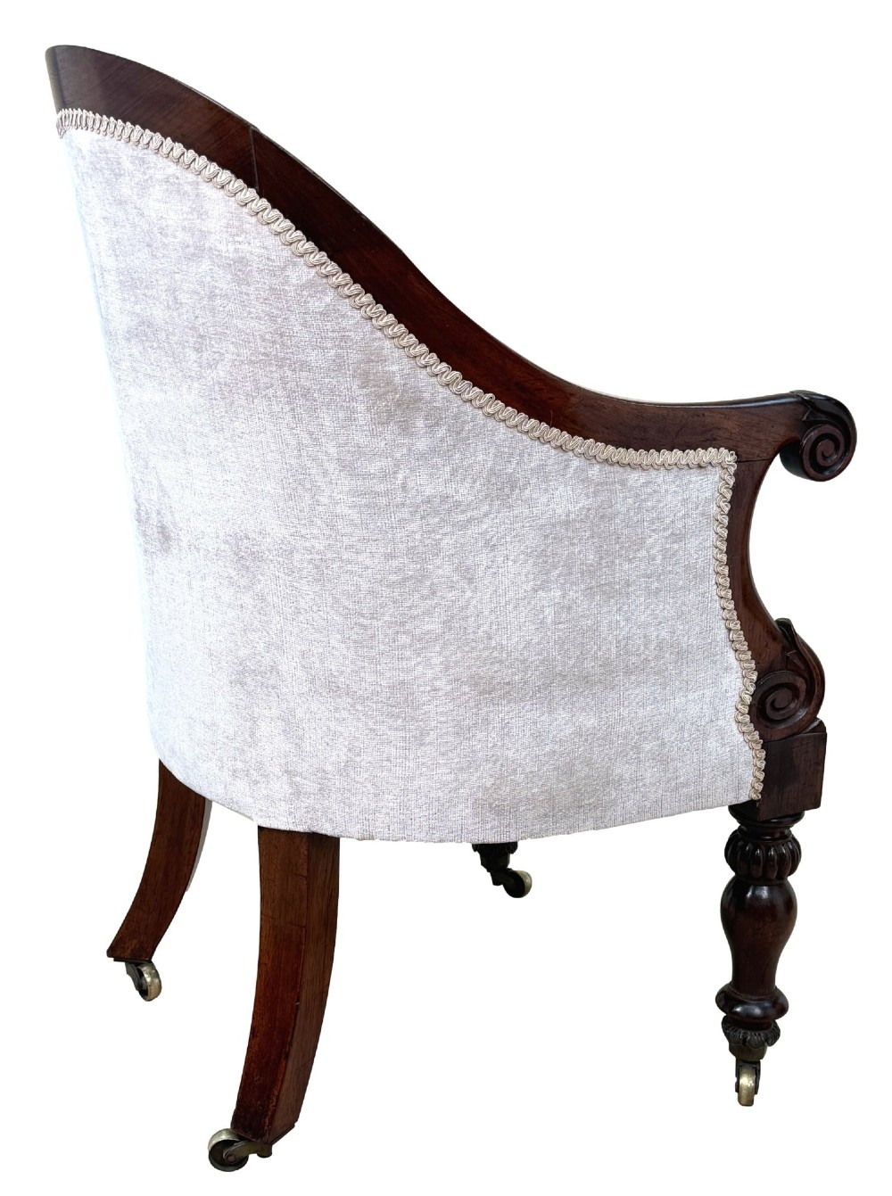 A 19th-century Regency period rosewood tub library armchair upholstered in cream fabric with turned legs and brass castors. View VIII