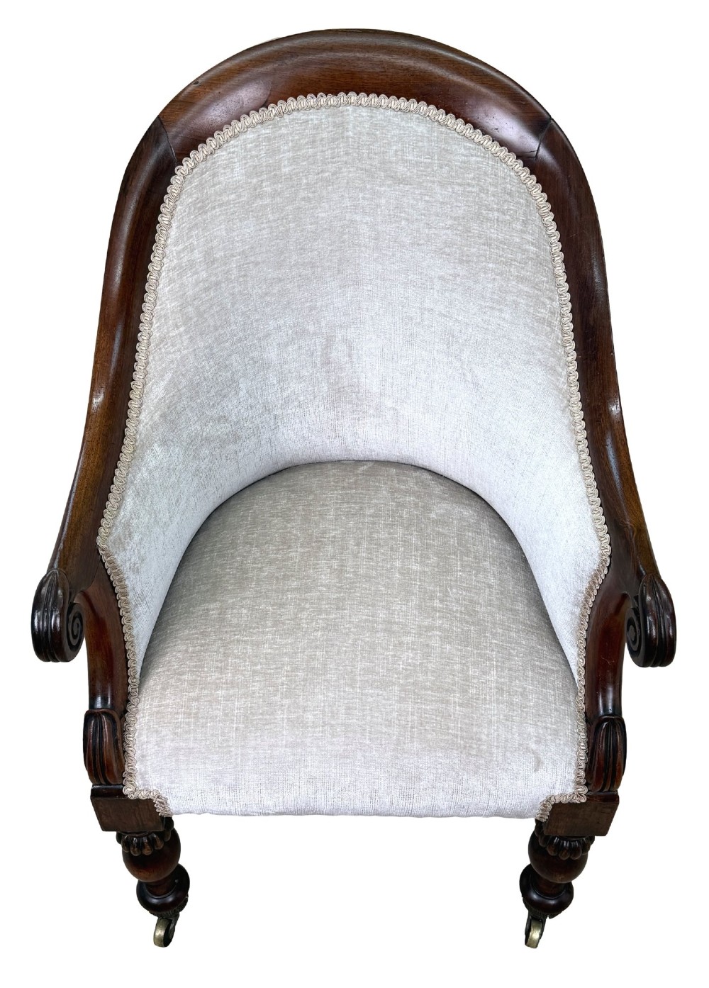 A 19th-century Regency period rosewood tub library armchair upholstered in cream fabric with turned legs and brass castors. View X