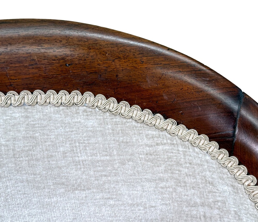 A 19th-century Regency period rosewood tub library armchair upholstered in cream fabric with turned legs and brass castors. View XII