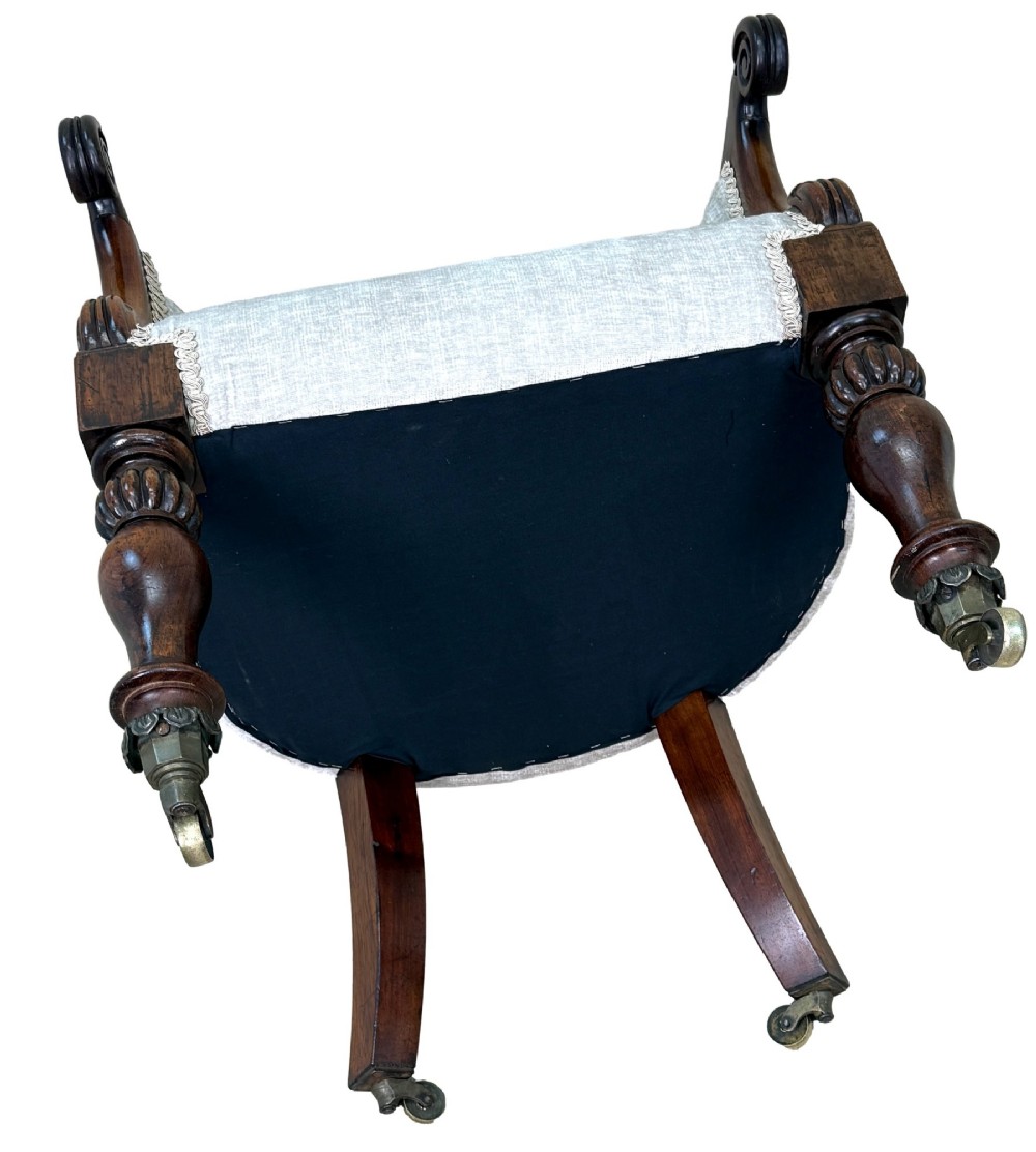 A 19th-century Regency period rosewood tub library armchair upholstered in cream fabric with turned legs and brass castors. View XIII