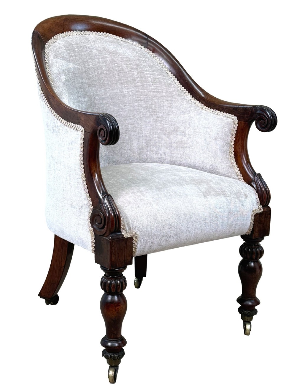 A 19th-century Regency period rosewood tub library armchair upholstered in cream fabric with turned legs and brass castors. View XIV