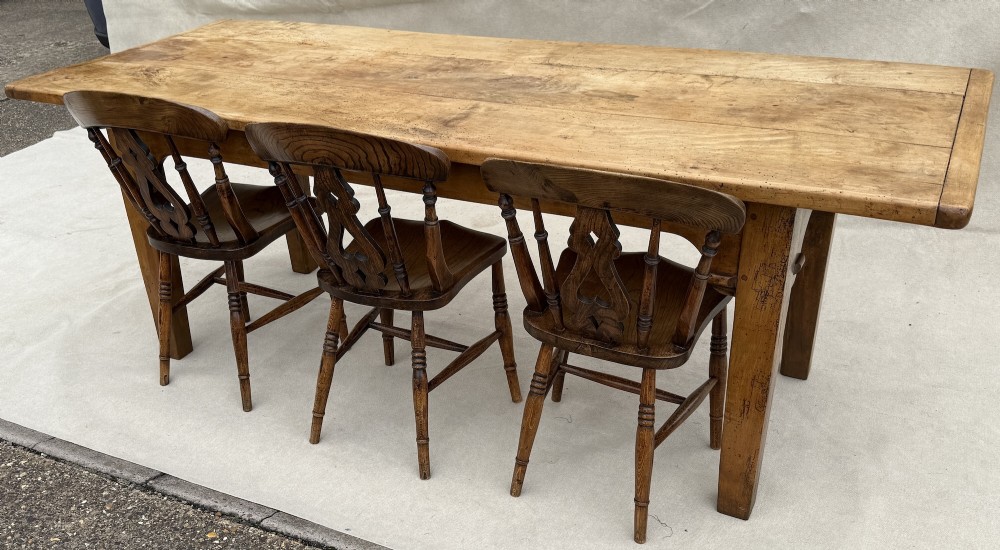 An early 19th-century French Provincial sycamore farmhouse dining table featuring a light wood plank top and tapered square legs. View XIII