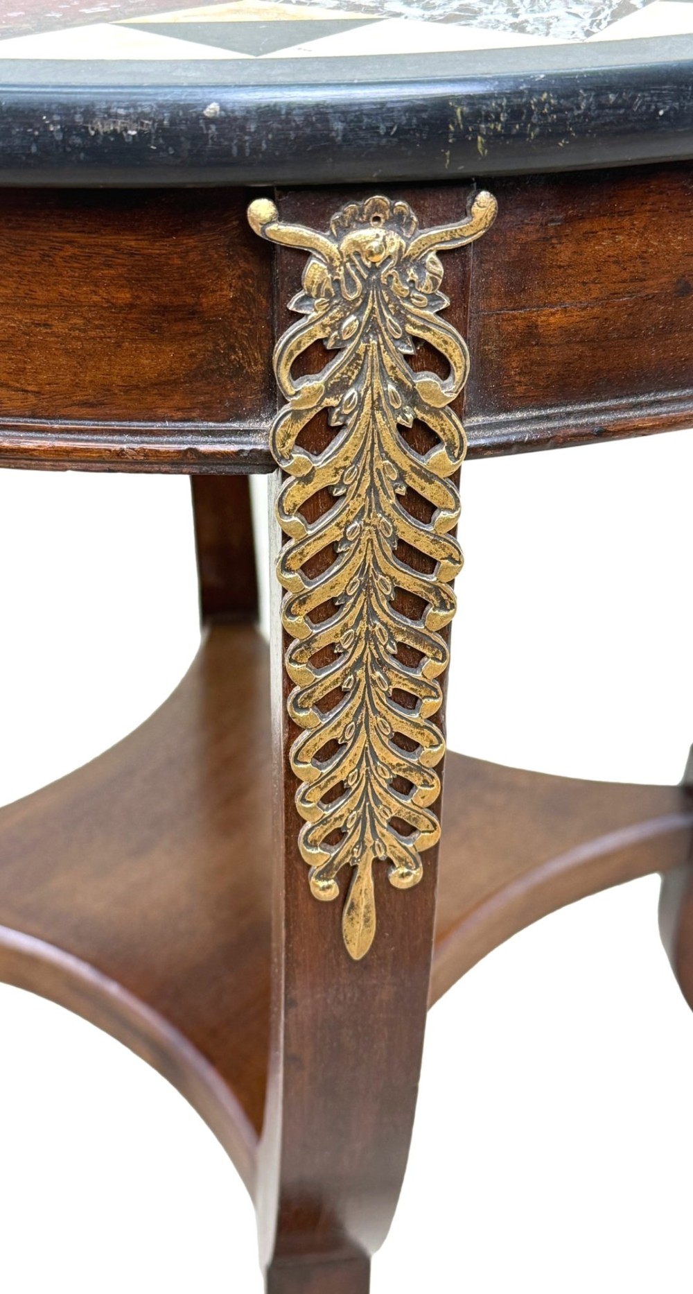 A late nineteenth-century circular mahogany occasional table featuring a specimen marble top, outcurving legs with gilt mounts, and a lower undertier. View II