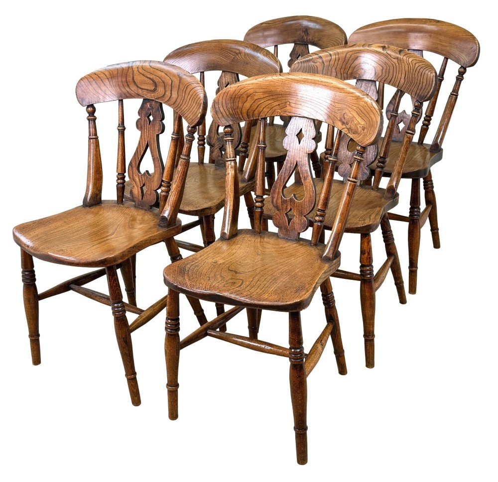 A set of six Victorian wooden Windsor dining chairs featuring shaped crest rails, pierced back splats, contoured saddle seats, and turned legs. View V
