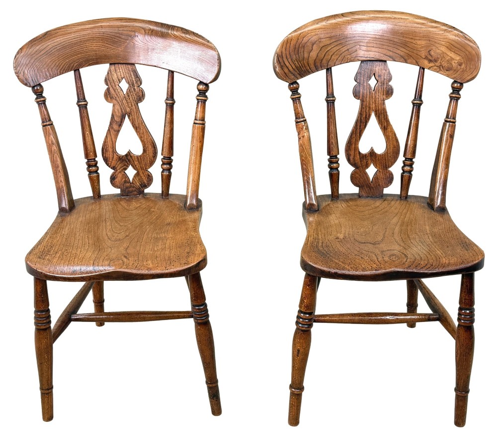 A set of six Victorian wooden Windsor dining chairs featuring shaped crest rails, pierced back splats, contoured saddle seats, and turned legs. View VI