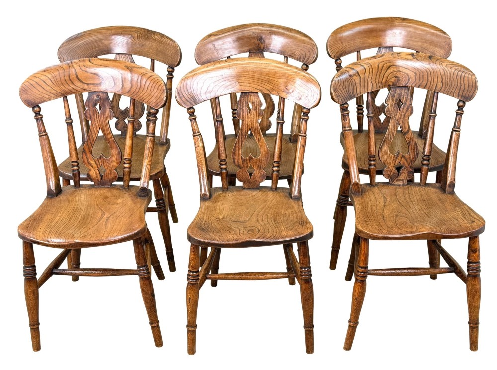 A set of six Victorian wooden Windsor dining chairs featuring shaped crest rails, pierced back splats, contoured saddle seats, and turned legs. View XIV