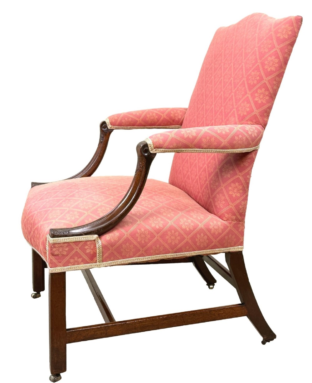 An 18th-century Georgian mahogany Gainsborough armchair with red patterned upholstery, curved carved arm supports, an H-stretcher frame, and brass castors. View III