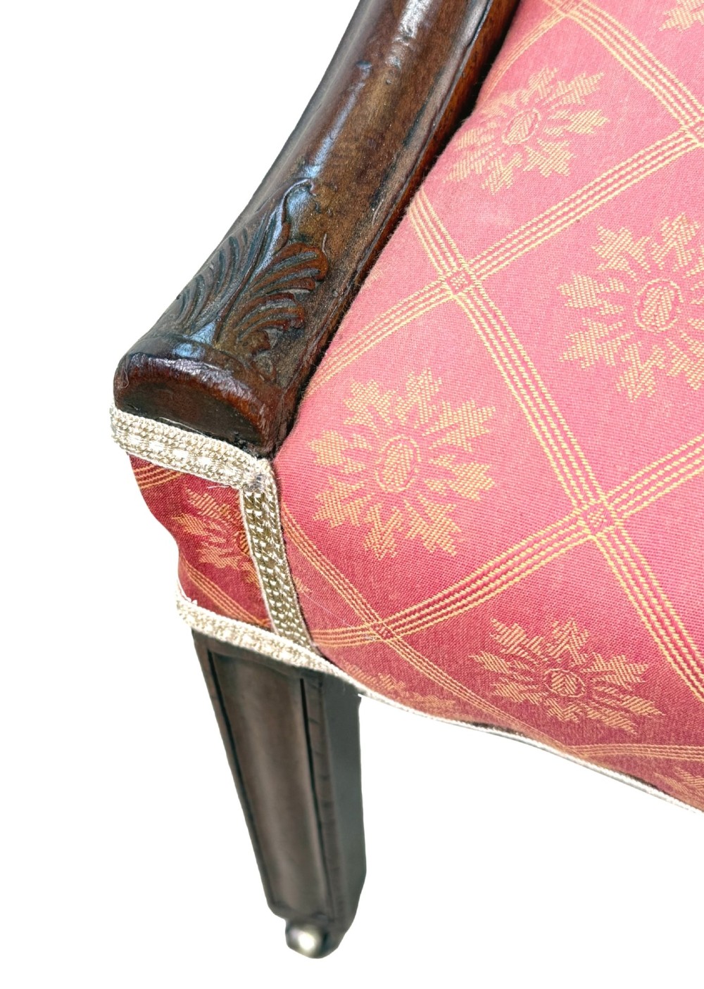 An 18th-century Georgian mahogany Gainsborough armchair with red patterned upholstery, curved carved arm supports, an H-stretcher frame, and brass castors. View V