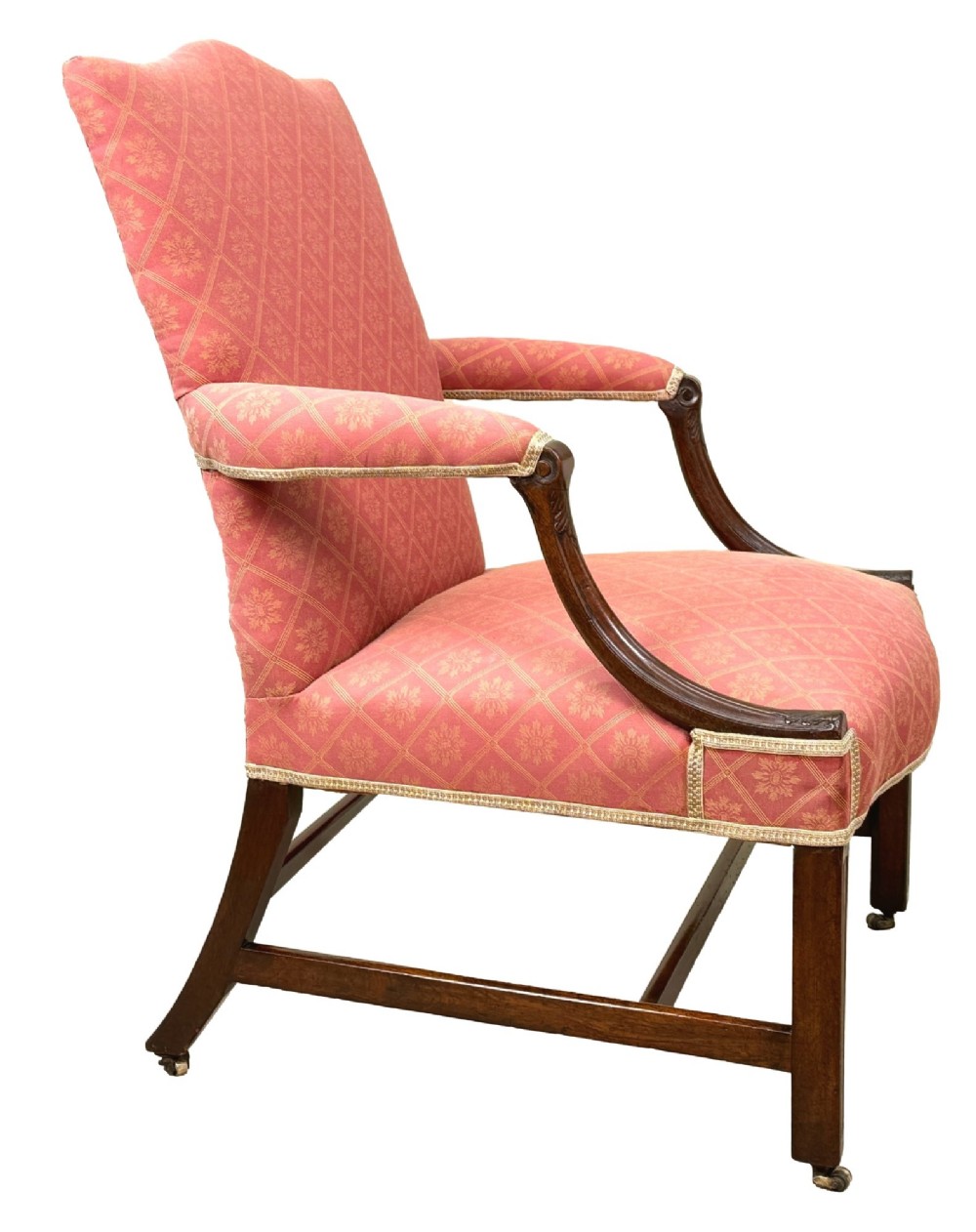 An 18th-century Georgian mahogany Gainsborough armchair with red patterned upholstery, curved carved arm supports, an H-stretcher frame, and brass castors. View VI