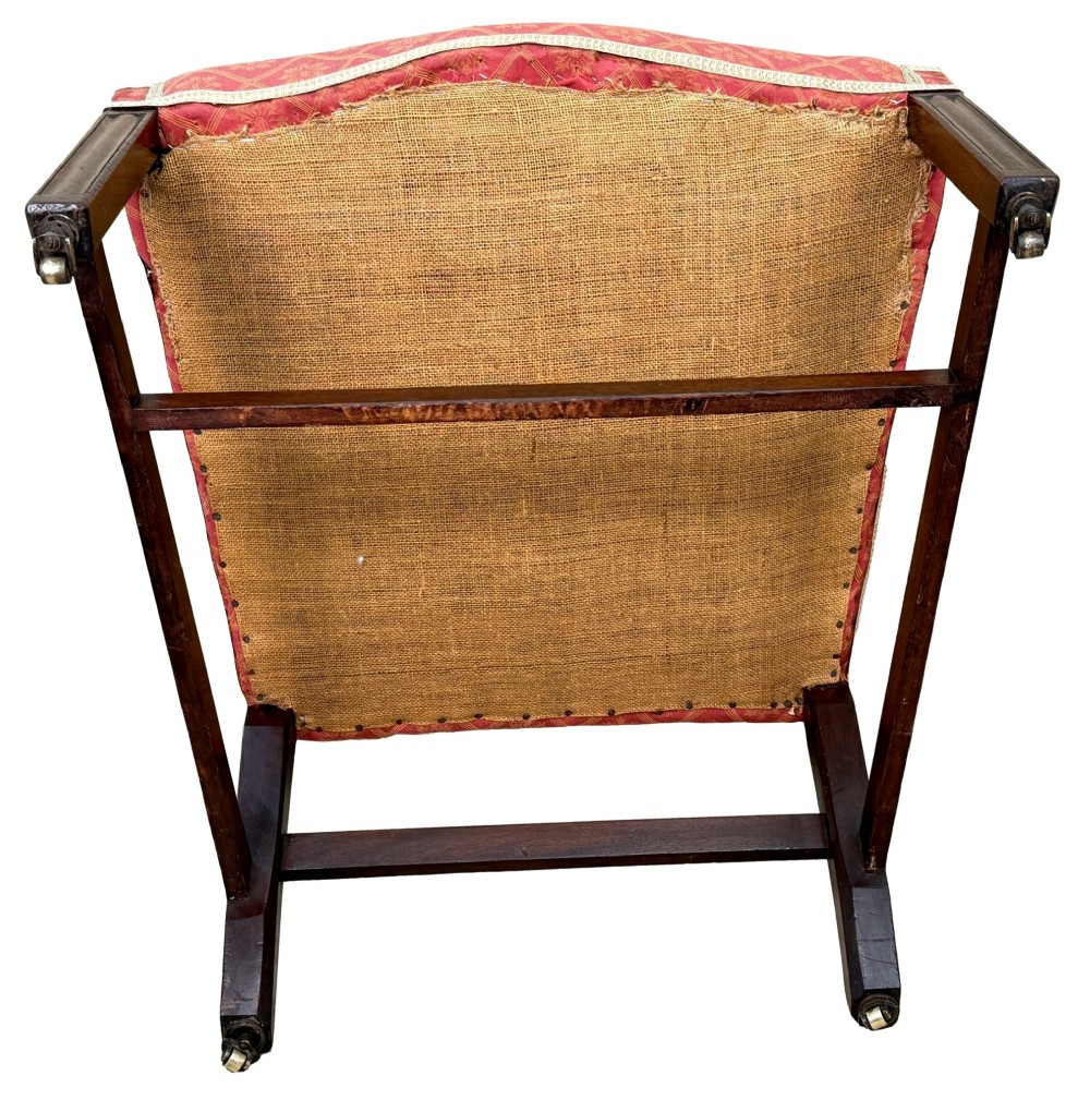 An 18th-century Georgian mahogany Gainsborough armchair with red patterned upholstery, curved carved arm supports, an H-stretcher frame, and brass castors. View XII