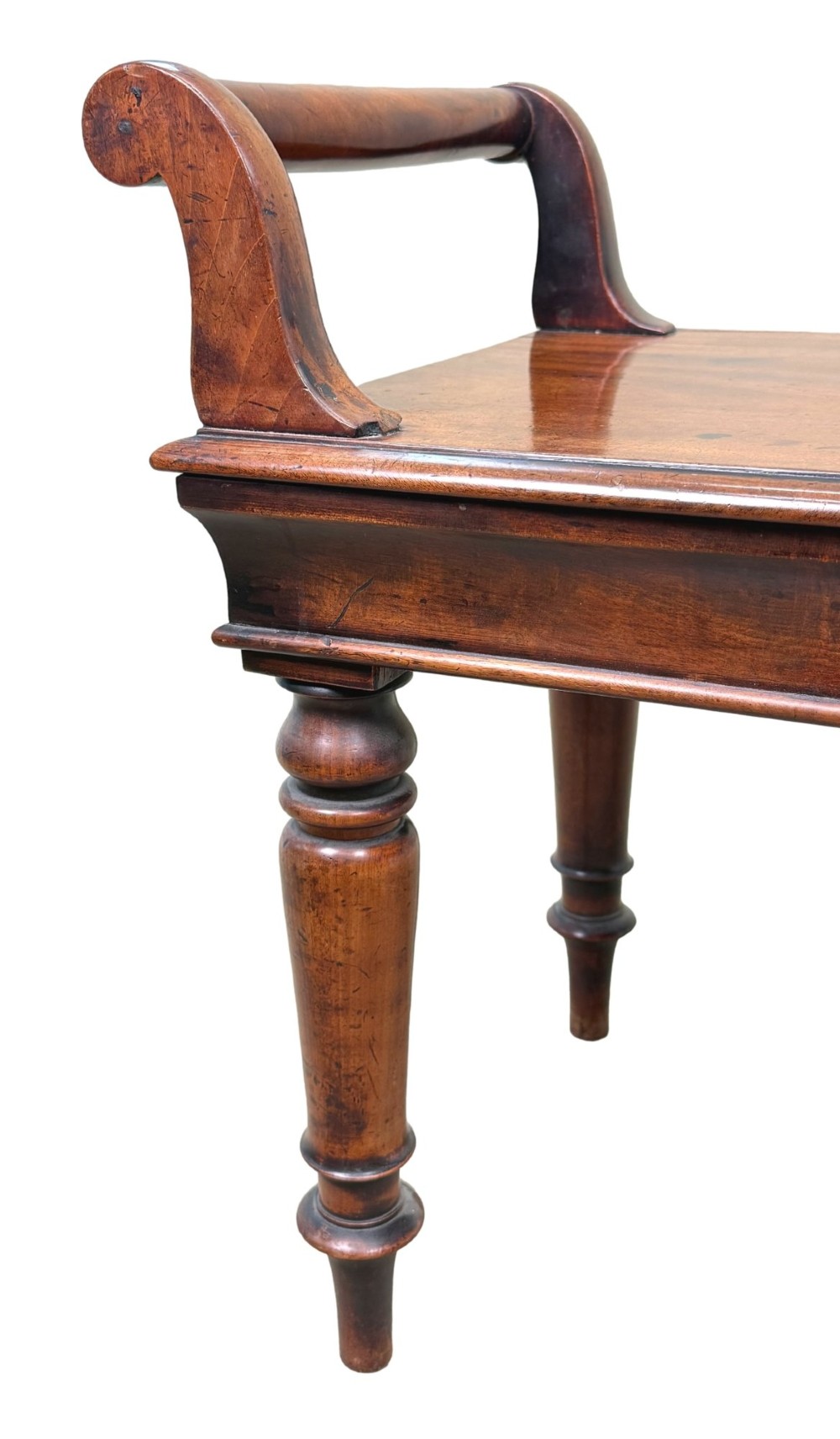 A mid-19th-century mahogany window seat with turned legs, a flat wooden seat, and curved end handles. View III