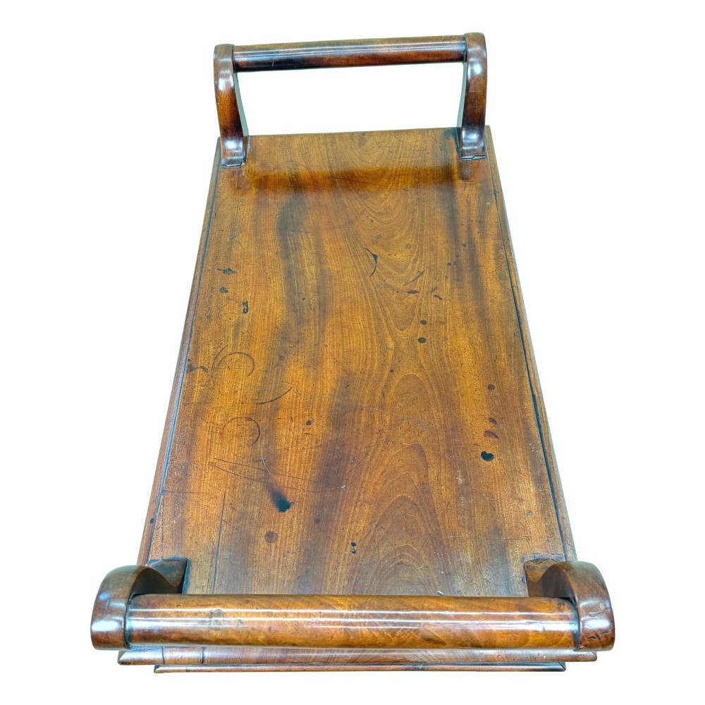 A mid-19th-century mahogany window seat with turned legs, a flat wooden seat, and curved end handles. View IV