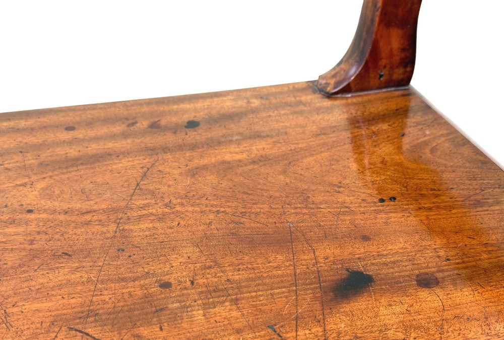 A mid-19th-century mahogany window seat with turned legs, a flat wooden seat, and curved end handles. View X