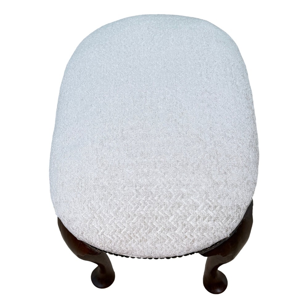 An early 18th-century George I walnut stool featuring an oval light grey upholstered seat trimmed with metal studs above four cabriole legs ending in pad feet. View III