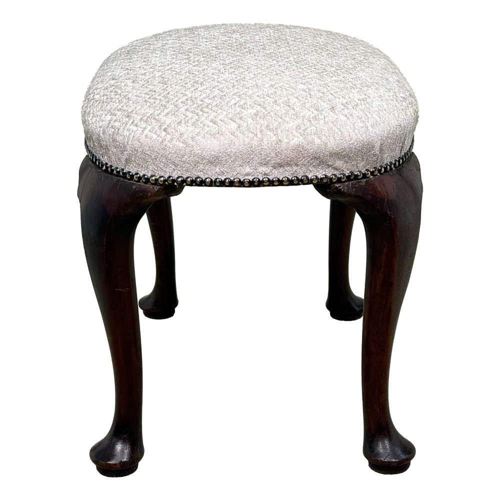 An early 18th-century George I walnut stool featuring an oval light grey upholstered seat trimmed with metal studs above four cabriole legs ending in pad feet. View VII