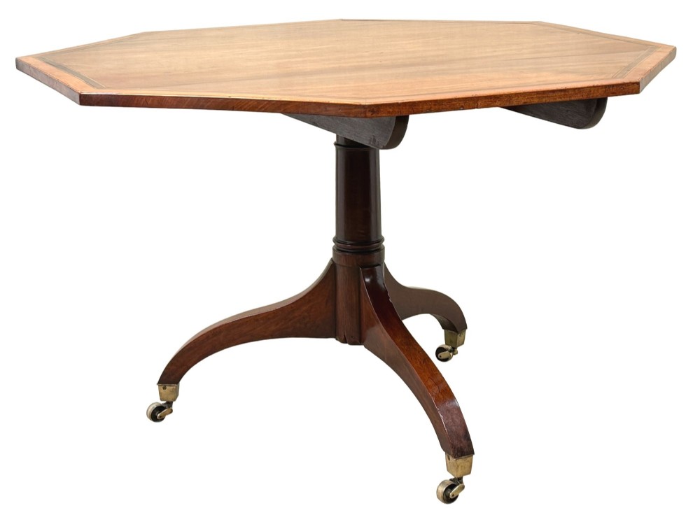 An 18th-century Georgian mahogany octagonal centre table with inlaid crossbanding, a central pedestal column, and tripod legs on brass castors. View VII