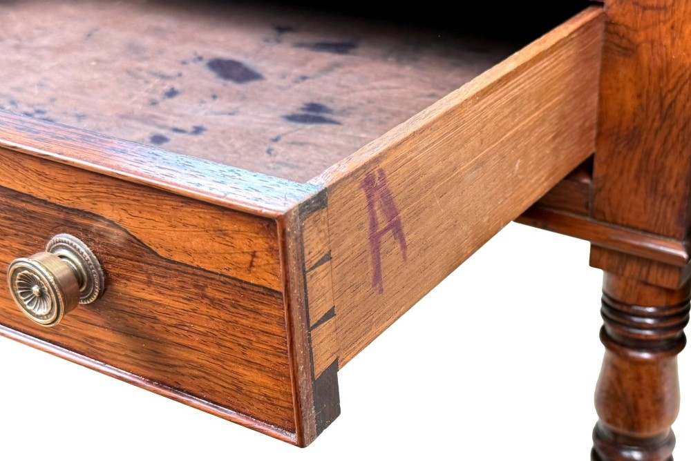 An early 19th-century Regency rosewood Pembroke table featuring extended drop leaves, turned legs on brass castors, and a single frieze drawer with brass knobs. View VII