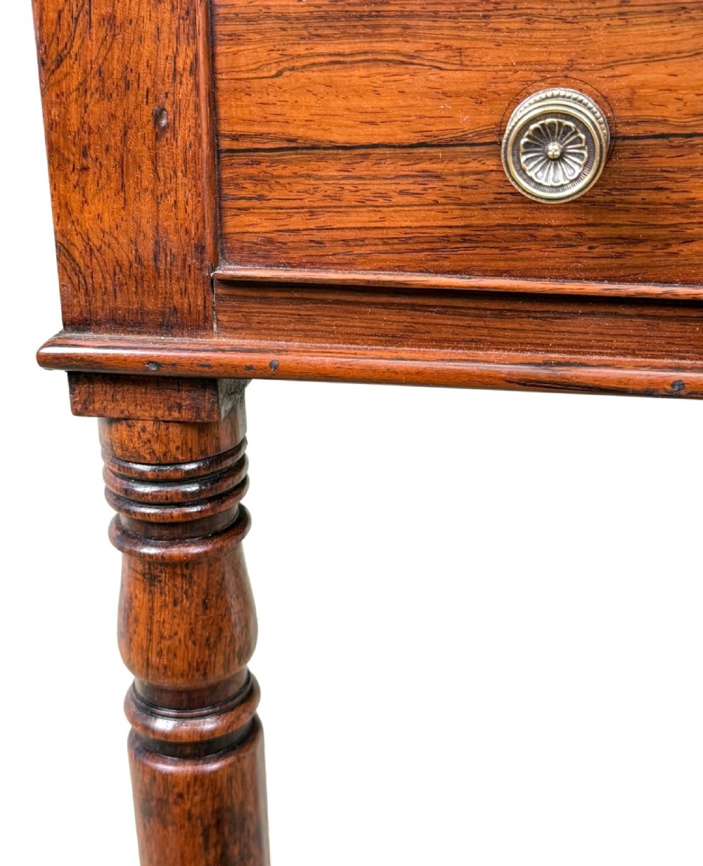 An early 19th-century Regency rosewood Pembroke table featuring extended drop leaves, turned legs on brass castors, and a single frieze drawer with brass knobs. View VIII