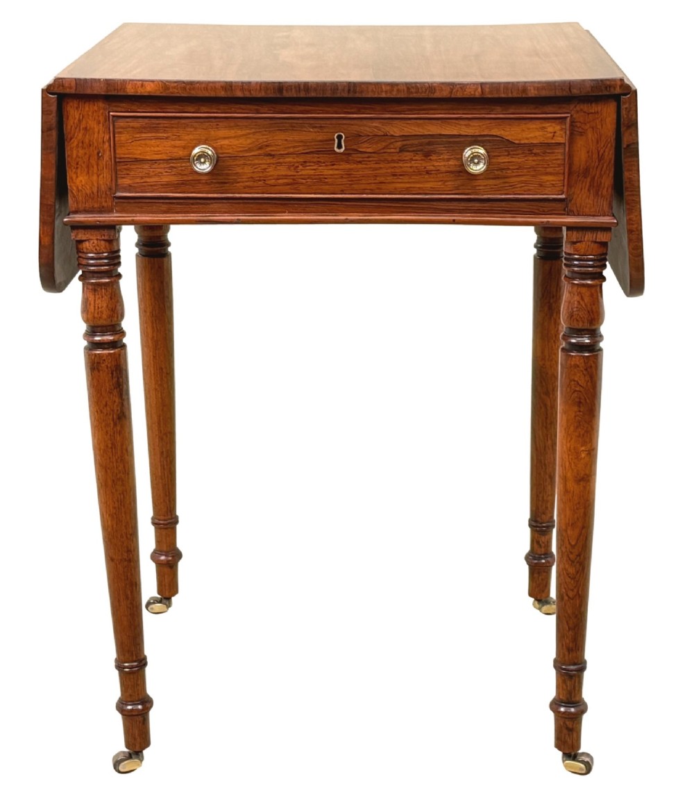 An early 19th-century Regency rosewood Pembroke table featuring extended drop leaves, turned legs on brass castors, and a single frieze drawer with brass knobs. View XI