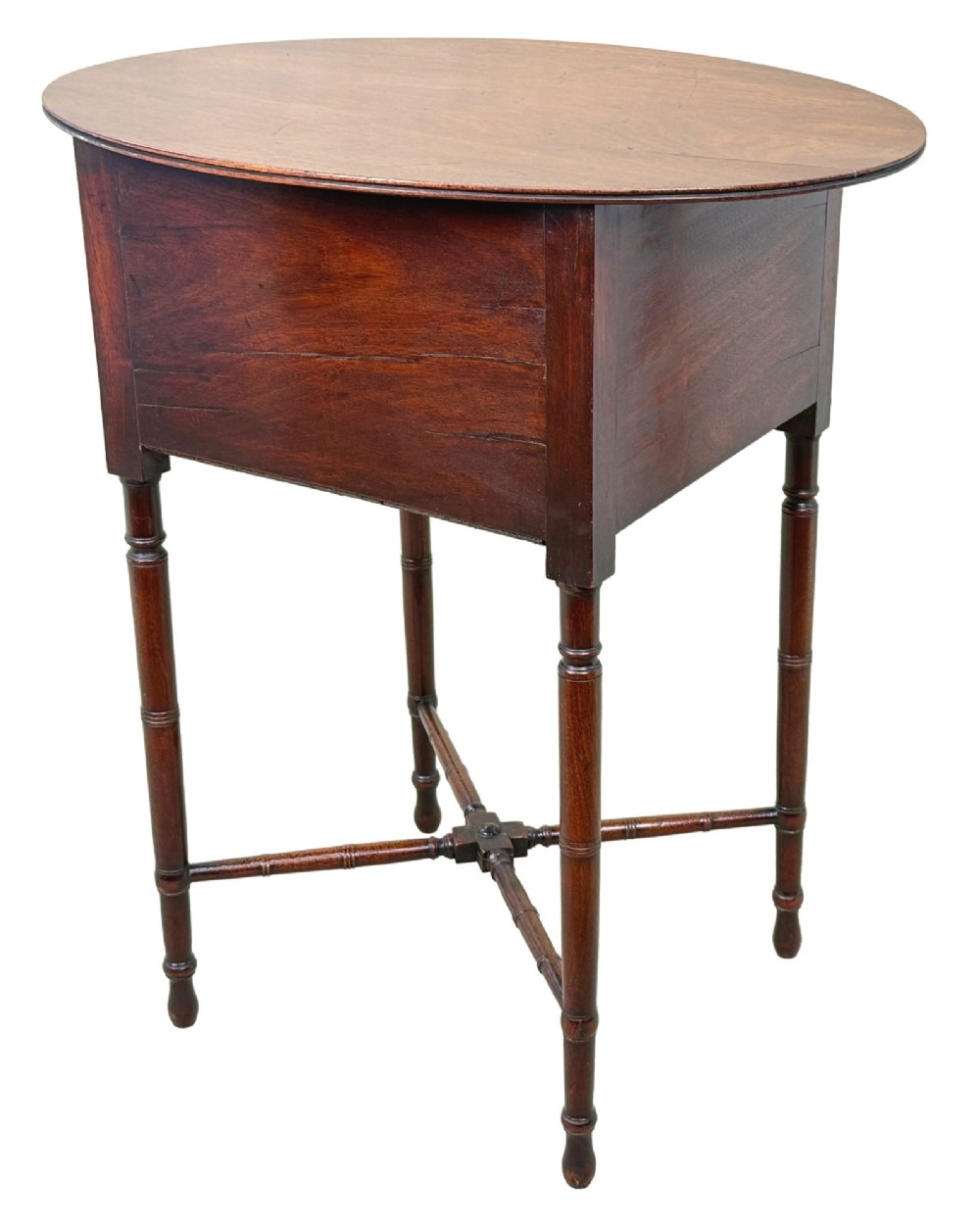 An early 19th-century Georgian mahogany side table featuring an oval top, single door cupboard with brass knob, turned legs, and an X-shaped cross stretcher. View VIII