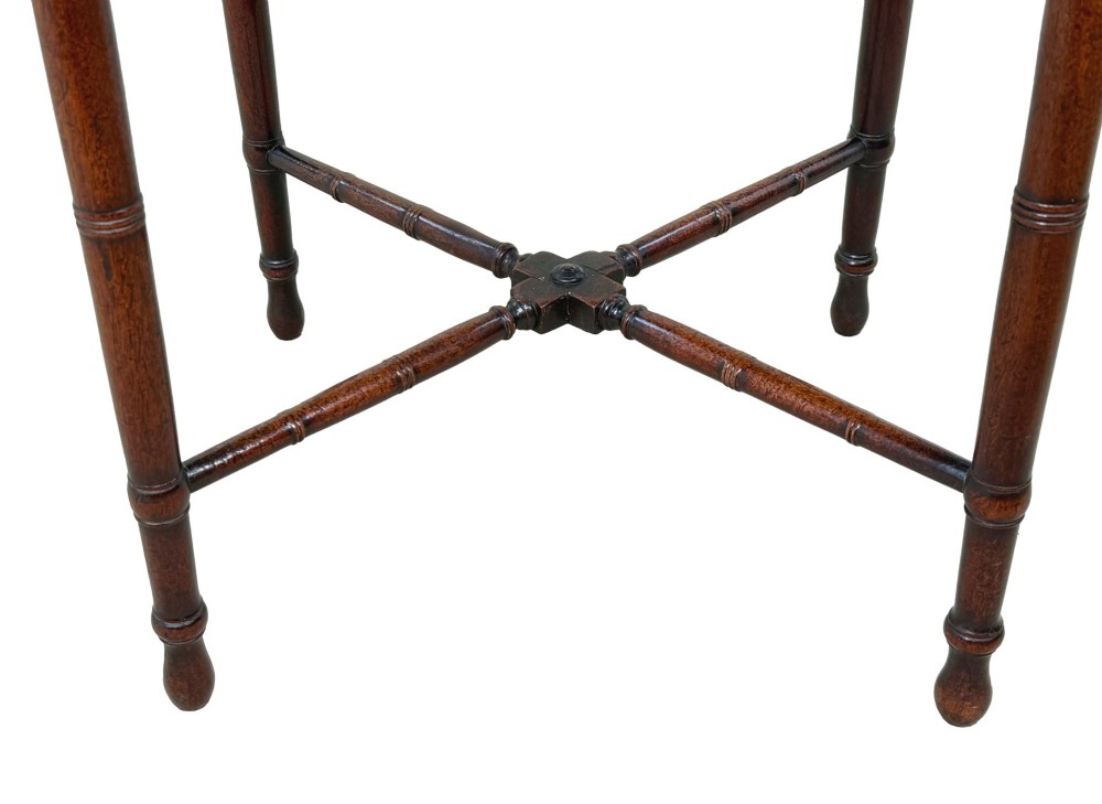 An early 19th-century Georgian mahogany side table featuring an oval top, single door cupboard with brass knob, turned legs, and an X-shaped cross stretcher. View IX