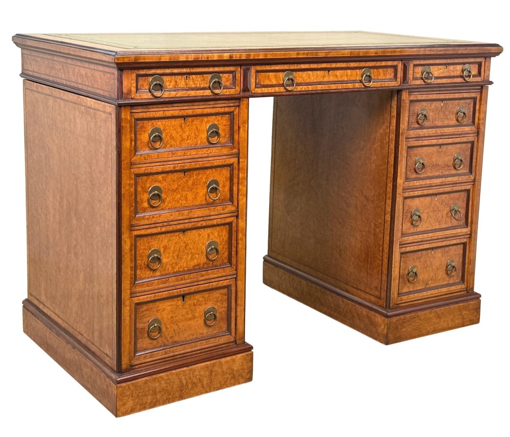A mid-19th-century English birdseye maple pedestal desk featuring a green leather writing surface, multiple drawers with brass ring drop handles, and a plinth base. View XI