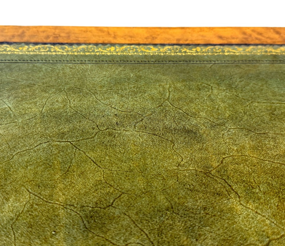 A mid-19th-century English birdseye maple pedestal desk featuring a green leather writing surface, multiple drawers with brass ring drop handles, and a plinth base. View XII