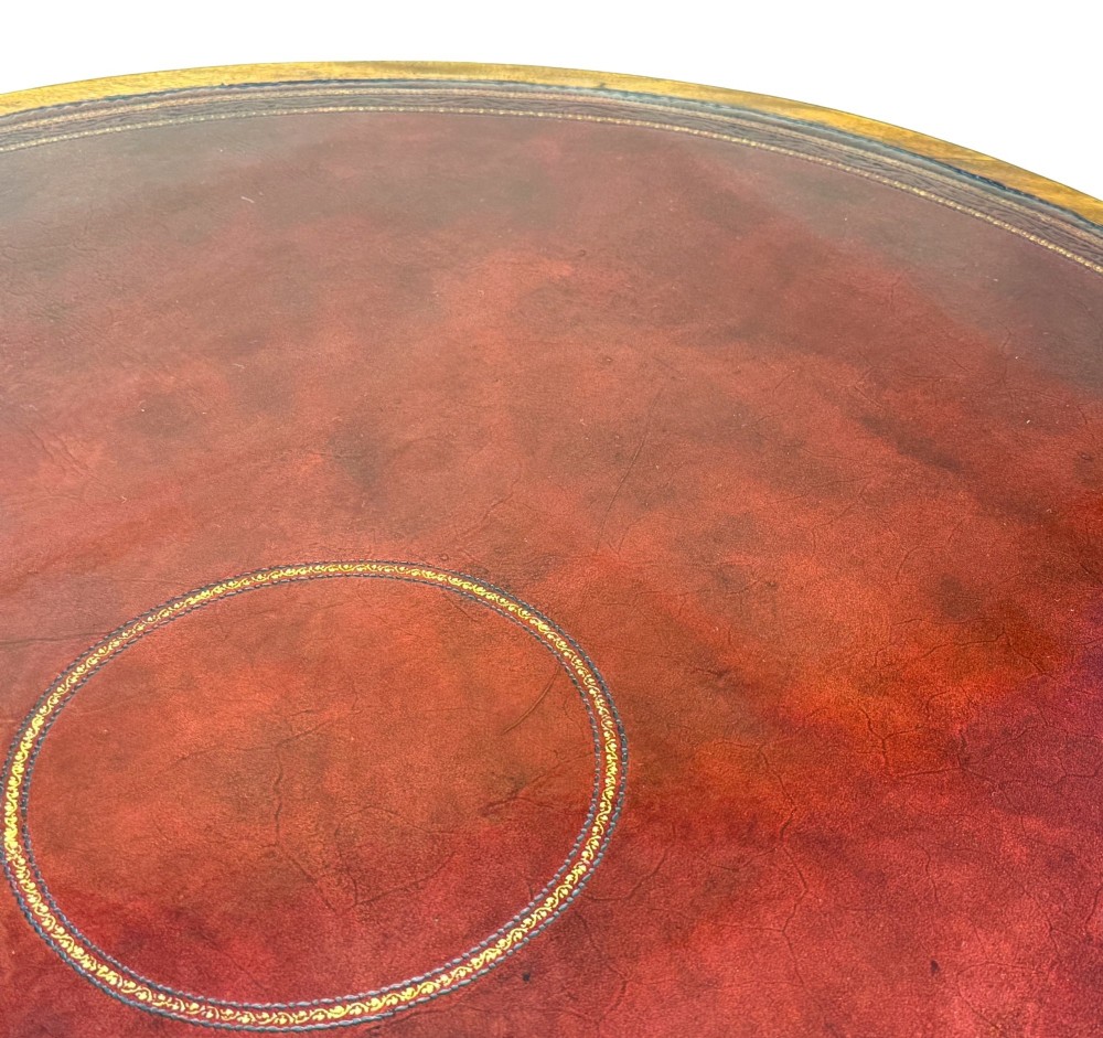 A circular Georgian mahogany drum table featuring a brown leather top, frieze drawers with brass ring handles, and a pedestal base with four splayed legs on brass paw castors. View IV