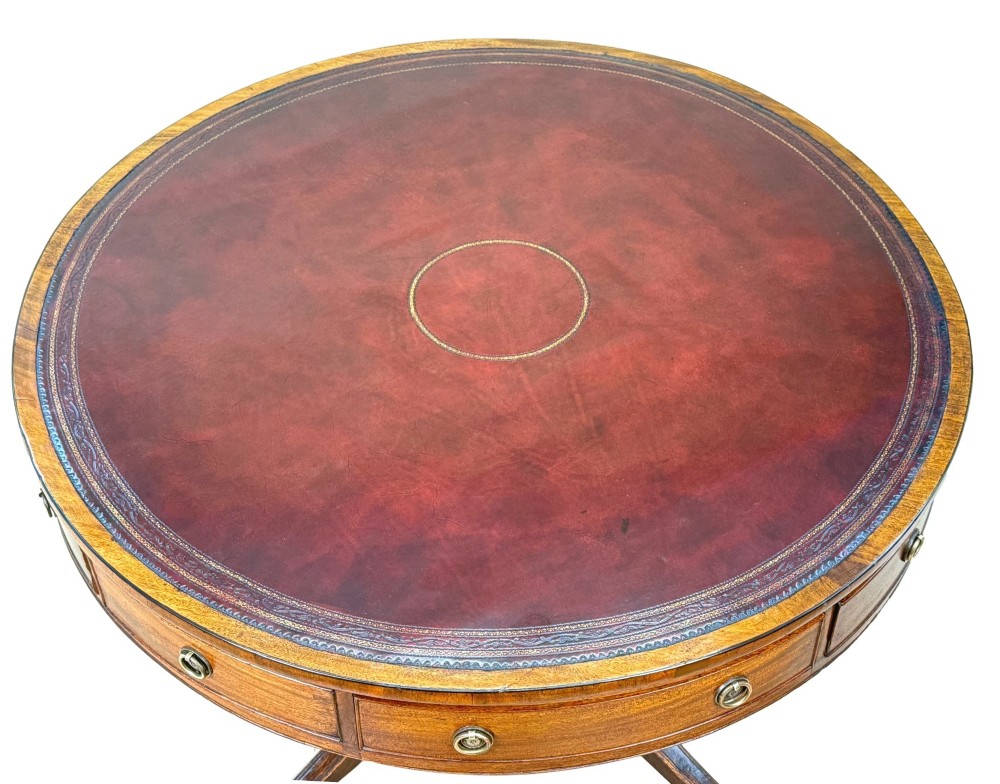 A circular Georgian mahogany drum table featuring a brown leather top, frieze drawers with brass ring handles, and a pedestal base with four splayed legs on brass paw castors. View IX
