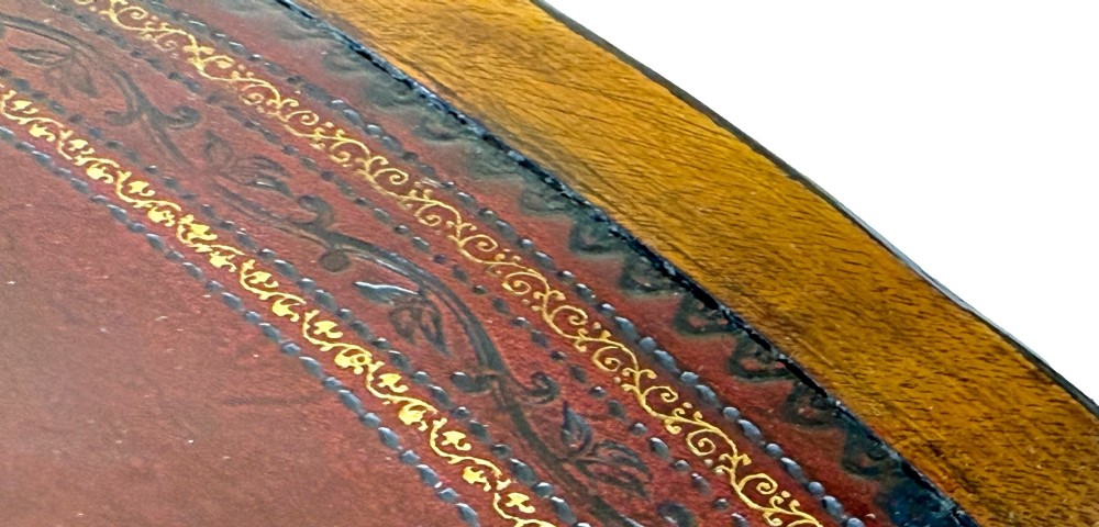 A circular Georgian mahogany drum table featuring a brown leather top, frieze drawers with brass ring handles, and a pedestal base with four splayed legs on brass paw castors. View X