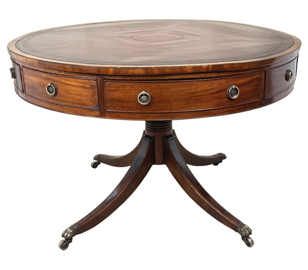 A circular Georgian mahogany drum table featuring a brown leather top, frieze drawers with brass ring handles, and a pedestal base with four splayed legs on brass paw castors. View XI