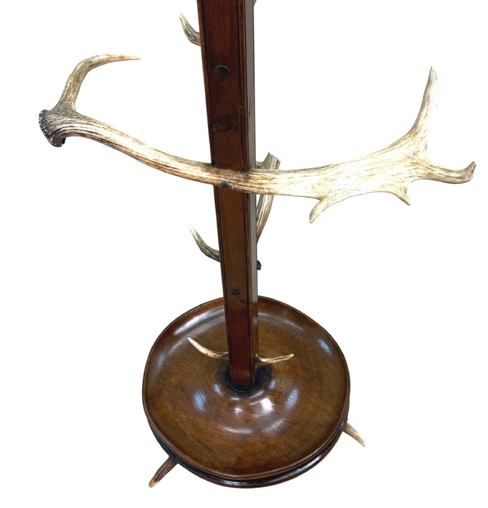 A 19th-century dark walnut hall stand featuring a central turned column mounted with stag antler hooks and a circular dish base. View IX