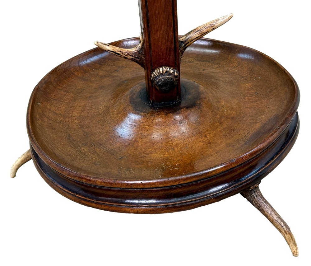 A 19th-century dark walnut hall stand featuring a central turned column mounted with stag antler hooks and a circular dish base. View XI