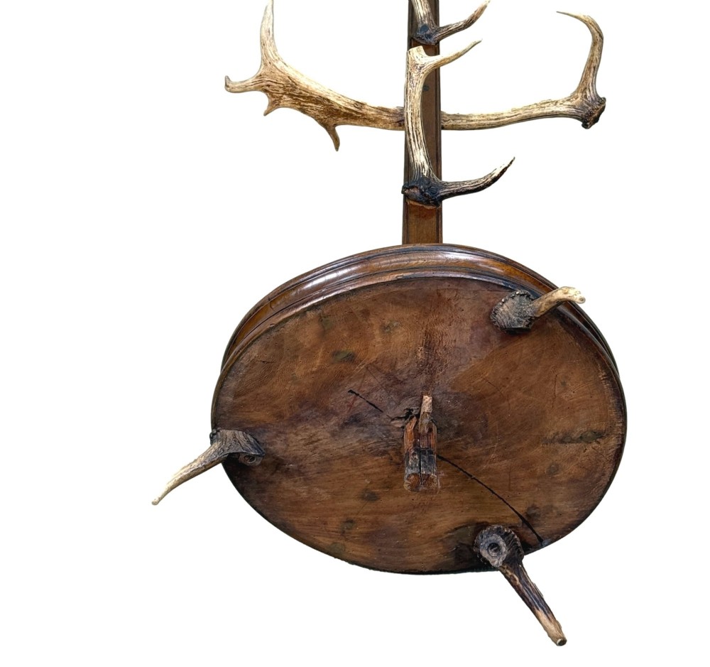 A 19th-century dark walnut hall stand featuring a central turned column mounted with stag antler hooks and a circular dish base. View XII