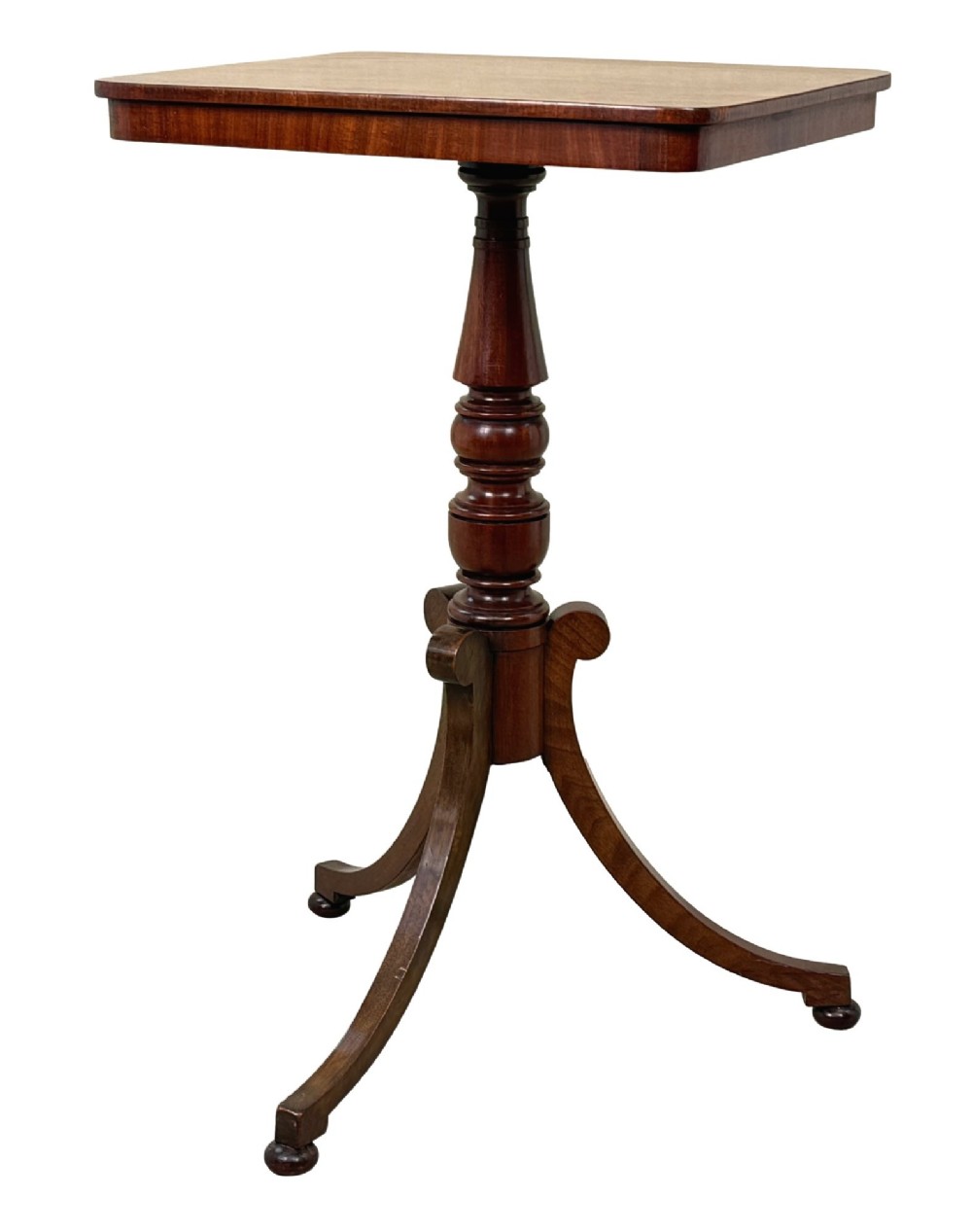 A Regency period mahogany wine table with a rectangular top, a turned central pedestal column, and three splayed legs ending in ball feet.