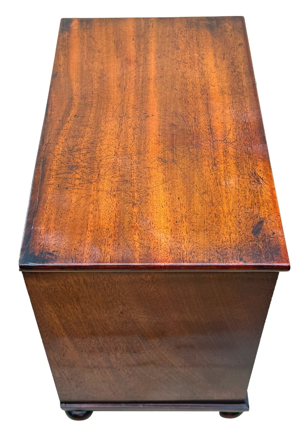 A mid-nineteenth-century miniature mahogany chest of drawers featuring two short over three long drawers, turned dark knobs, and bun feet. View XI