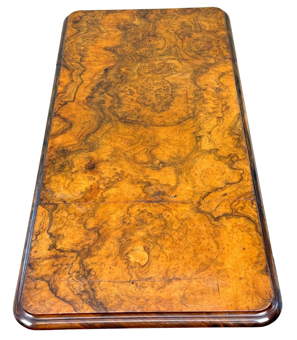 A 19th-century burr walnut Pembroke side table with a single drawer, two drop-down side leaves, turned fluted legs, and brass castors. View III