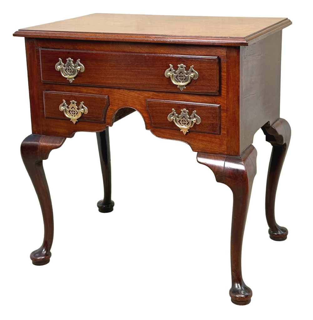 An early Georgian mahogany lowboy table featuring three drawers with brass handles, a shaped apron, and four cabriole legs.
