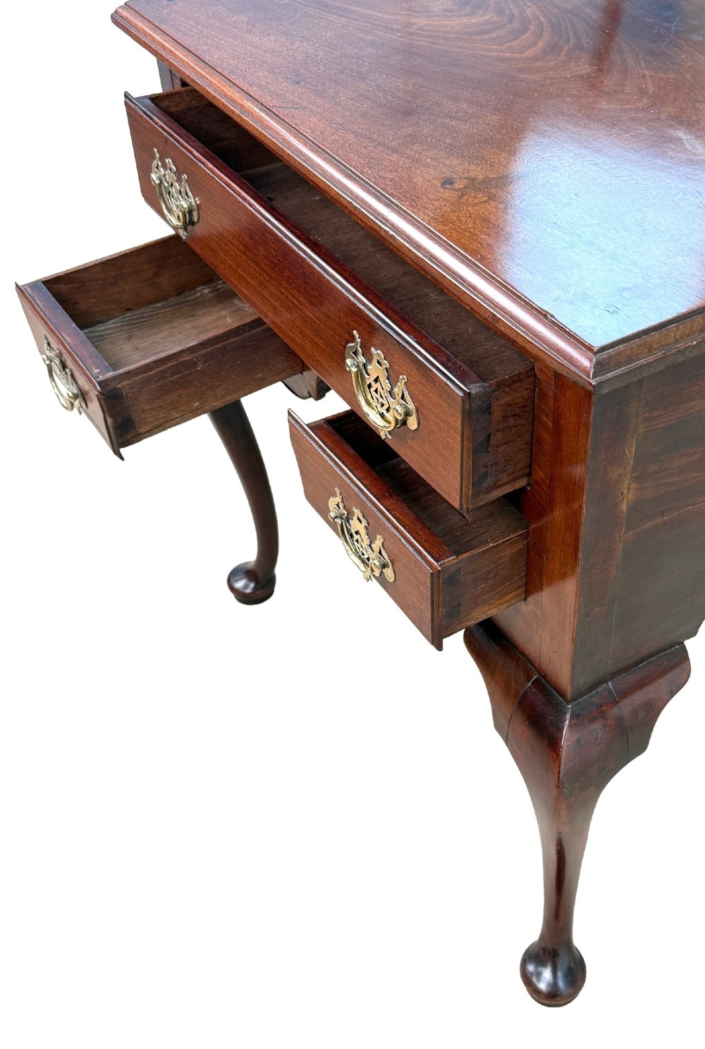 An early Georgian mahogany lowboy table featuring three drawers with brass handles, a shaped apron, and four cabriole legs. View IV