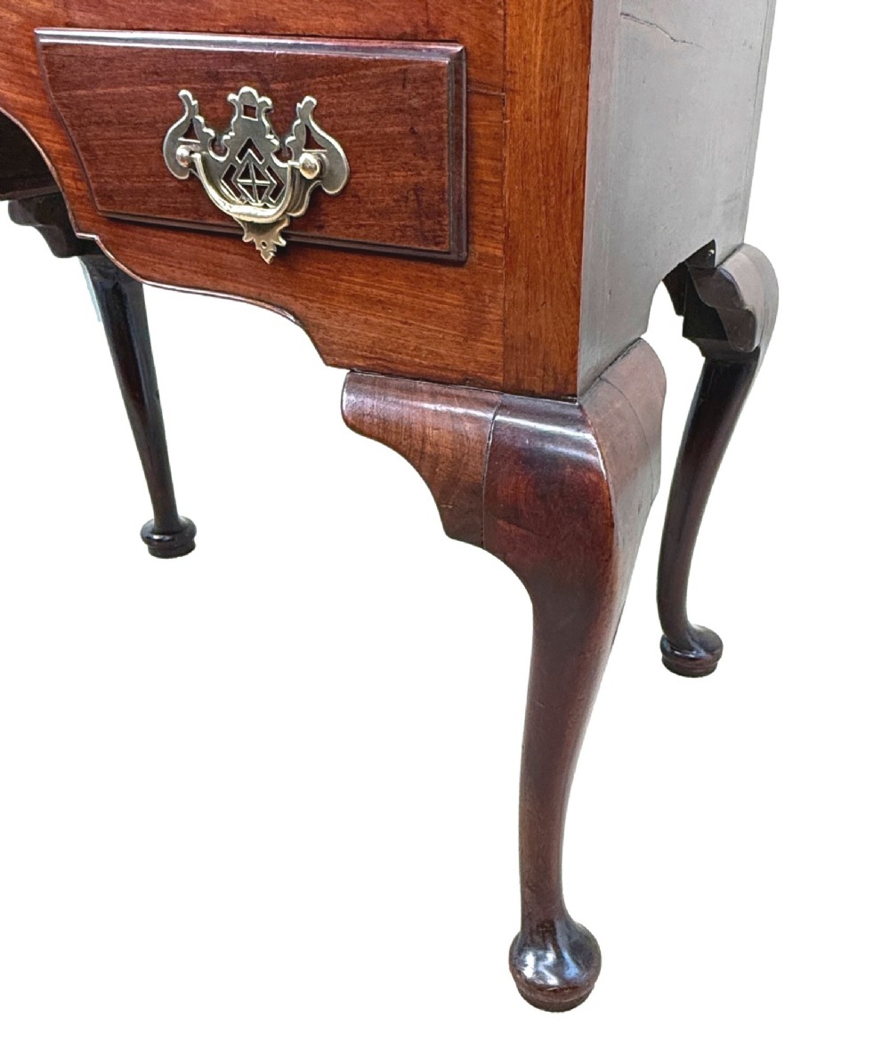 An early Georgian mahogany lowboy table featuring three drawers with brass handles, a shaped apron, and four cabriole legs. View VII