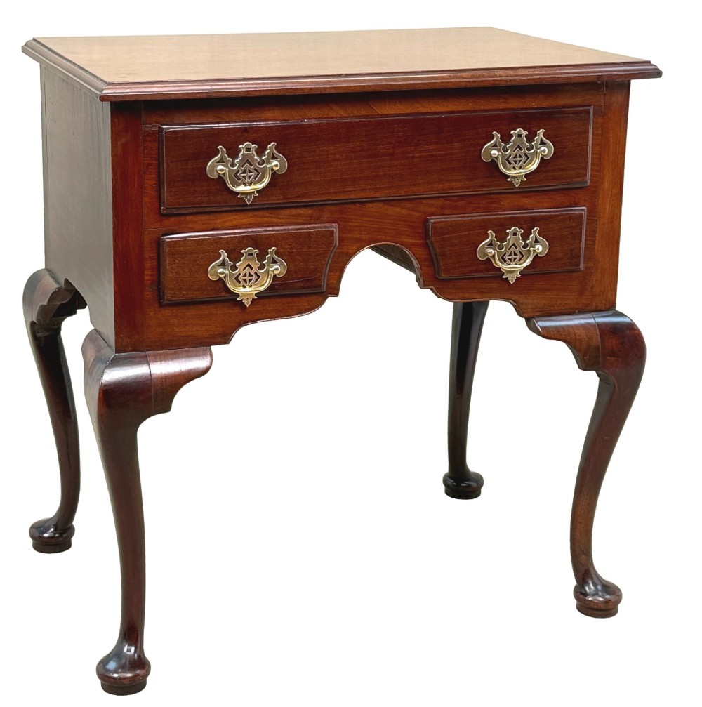 An early Georgian mahogany lowboy table featuring three drawers with brass handles, a shaped apron, and four cabriole legs. View X