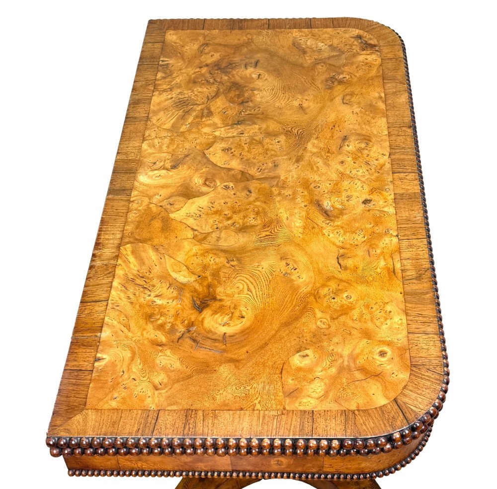 An early 19th-century Regency period pollard oak fold-over tea table featuring a rectangular top, beaded edging, a central pedestal support, and a quadripartite base resting on carved claw feet. View III