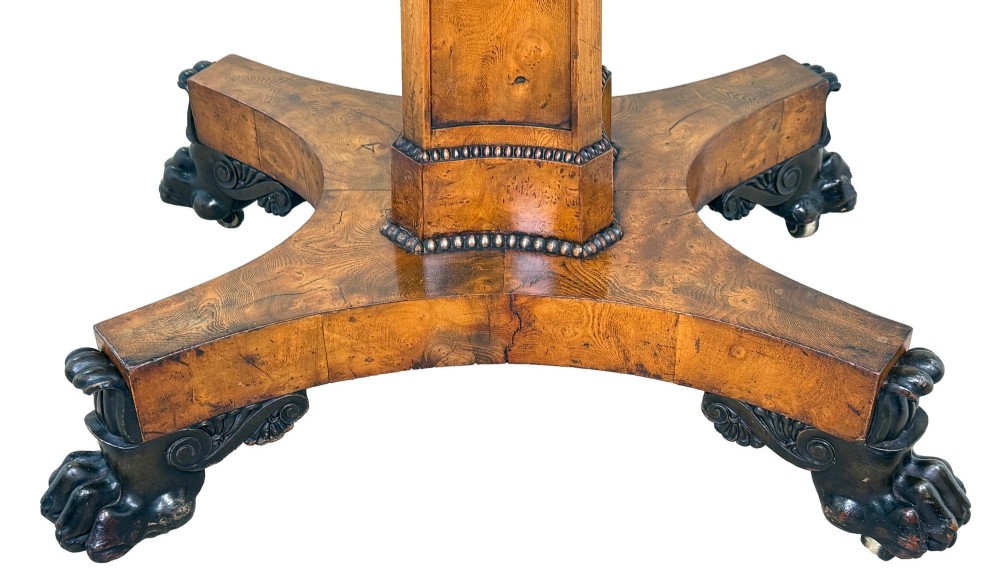 An early 19th-century Regency period pollard oak fold-over tea table featuring a rectangular top, beaded edging, a central pedestal support, and a quadripartite base resting on carved claw feet. View VIII