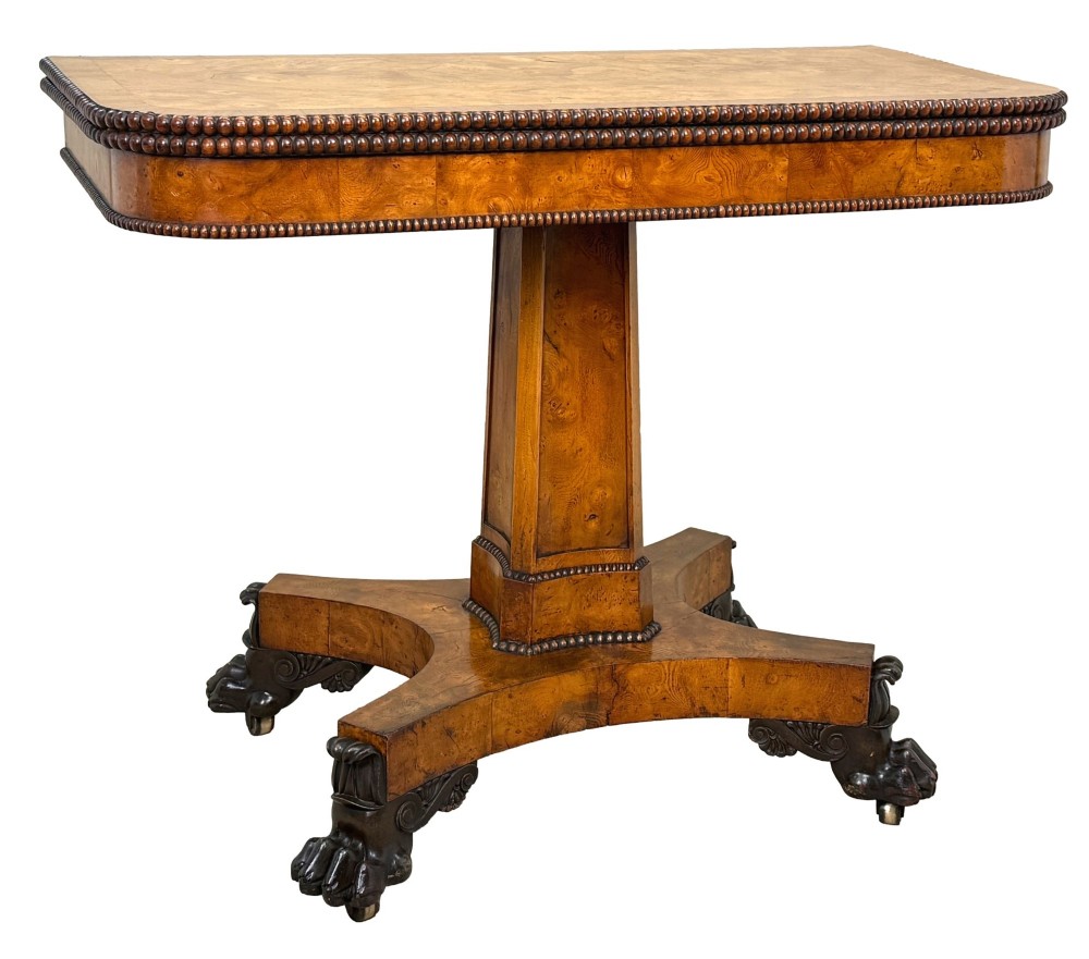 An early 19th-century Regency period pollard oak fold-over tea table featuring a rectangular top, beaded edging, a central pedestal support, and a quadripartite base resting on carved claw feet. View IX