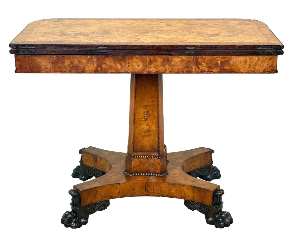 An early 19th-century Regency period pollard oak fold-over tea table featuring a rectangular top, beaded edging, a central pedestal support, and a quadripartite base resting on carved claw feet. View X