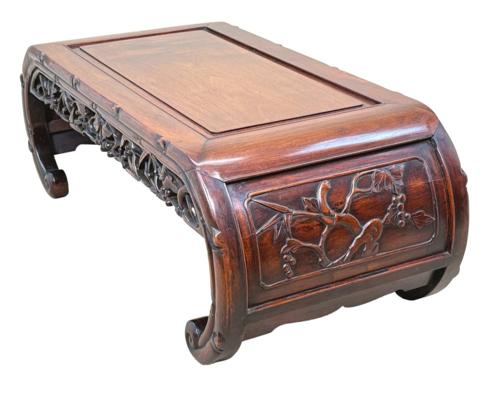 A 19th-century dark hardwood Chinese export opium coffee table featuring scrolled legs and intricately carved pierced floral aprons. View II