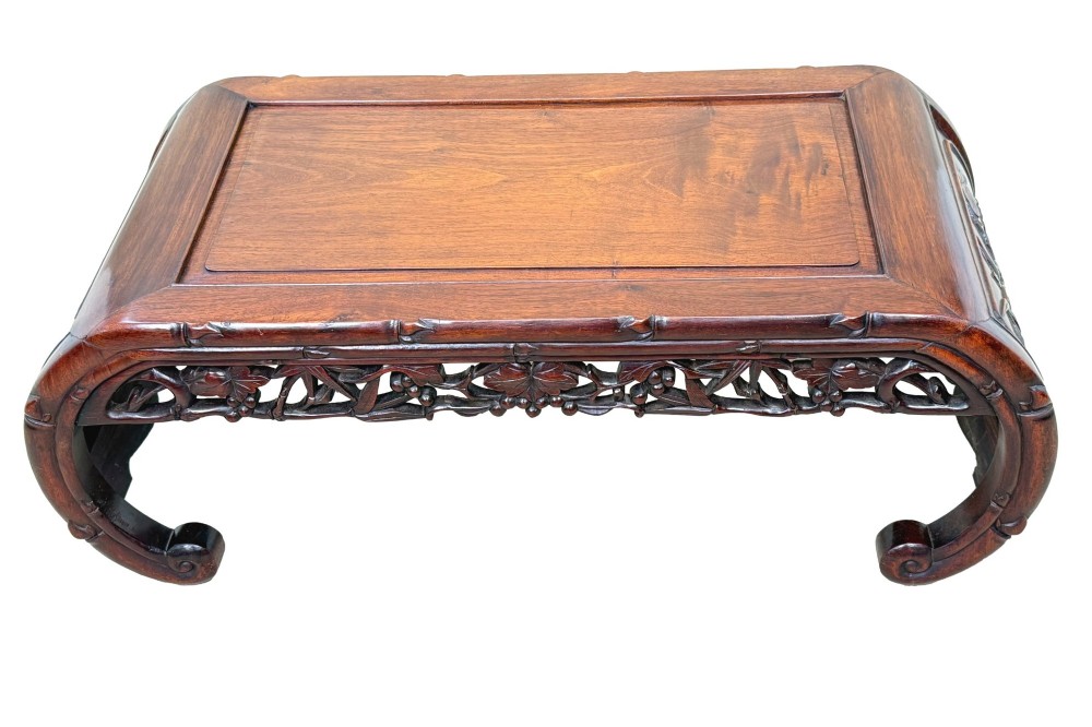 A 19th-century dark hardwood Chinese export opium coffee table featuring scrolled legs and intricately carved pierced floral aprons. View IV