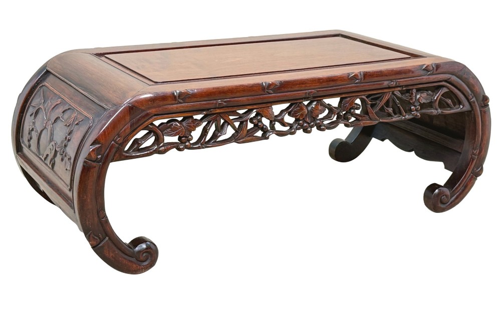 A 19th-century dark hardwood Chinese export opium coffee table featuring scrolled legs and intricately carved pierced floral aprons. View VI