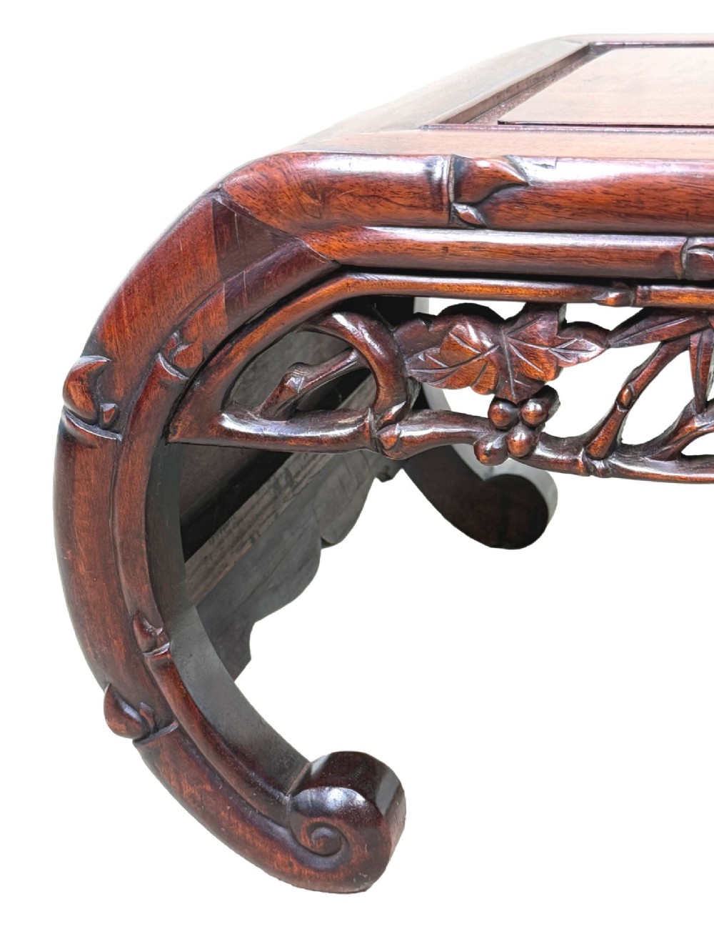 A 19th-century dark hardwood Chinese export opium coffee table featuring scrolled legs and intricately carved pierced floral aprons. View VII