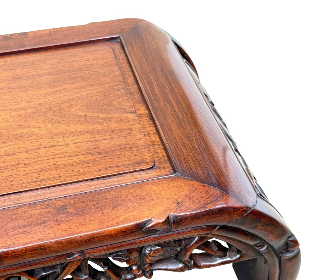 A 19th-century dark hardwood Chinese export opium coffee table featuring scrolled legs and intricately carved pierced floral aprons. View IX